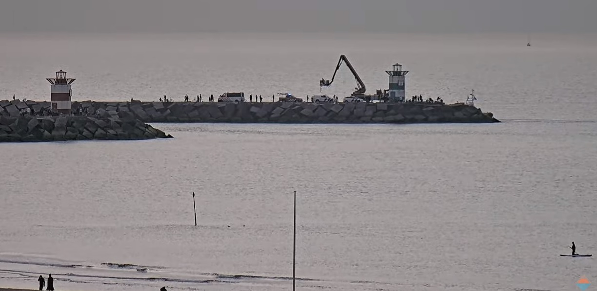 Man tussen blokken op Zuidelijk havenhoofd